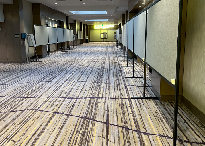 Four by eight foot poster boards lined up along the hotel hallway at the Hilton Long Beach